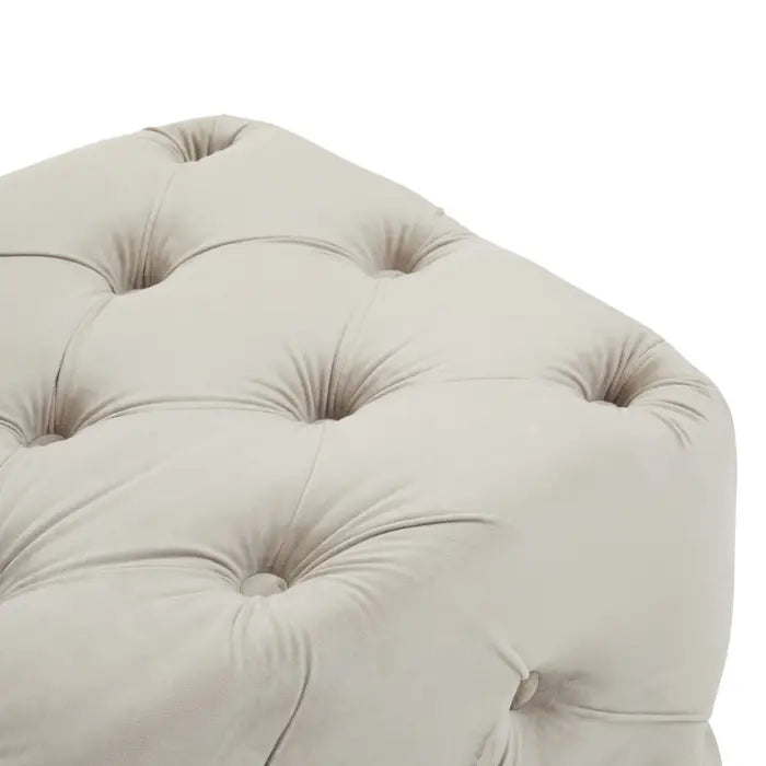 Plain white background with traditional button-tufted bench, upholstered with soft touch mink velvet, close up image.