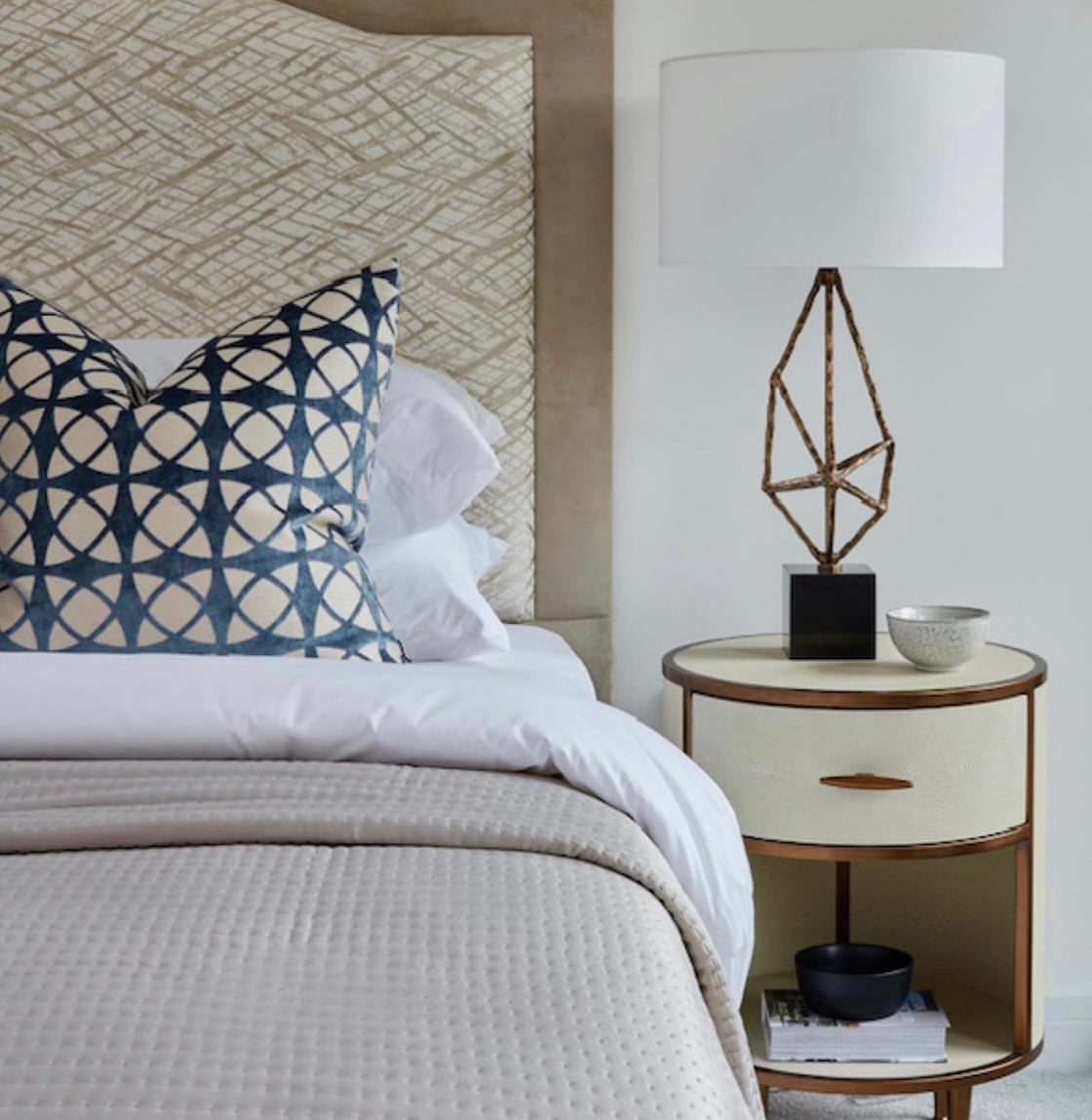 This bedside table comes equipped with a faux shagreen finish in ivory, antique brass surround and handles.