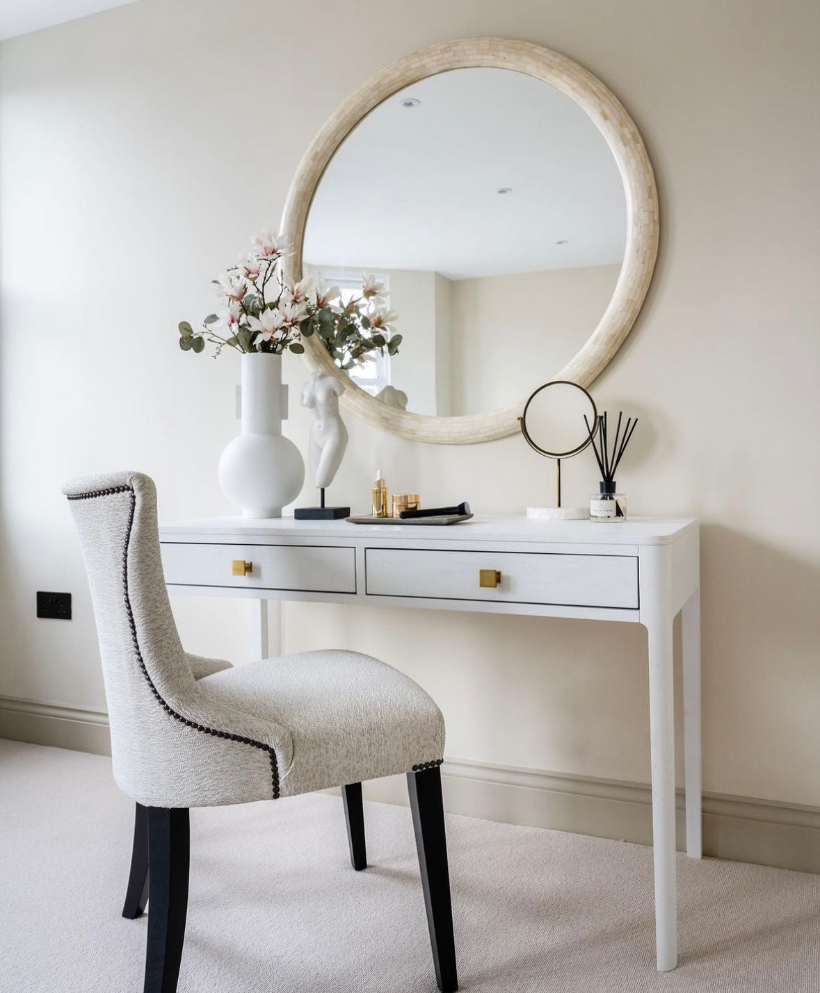 White console table with Gold handle details in a neutral setting with beauty chair and mirror.