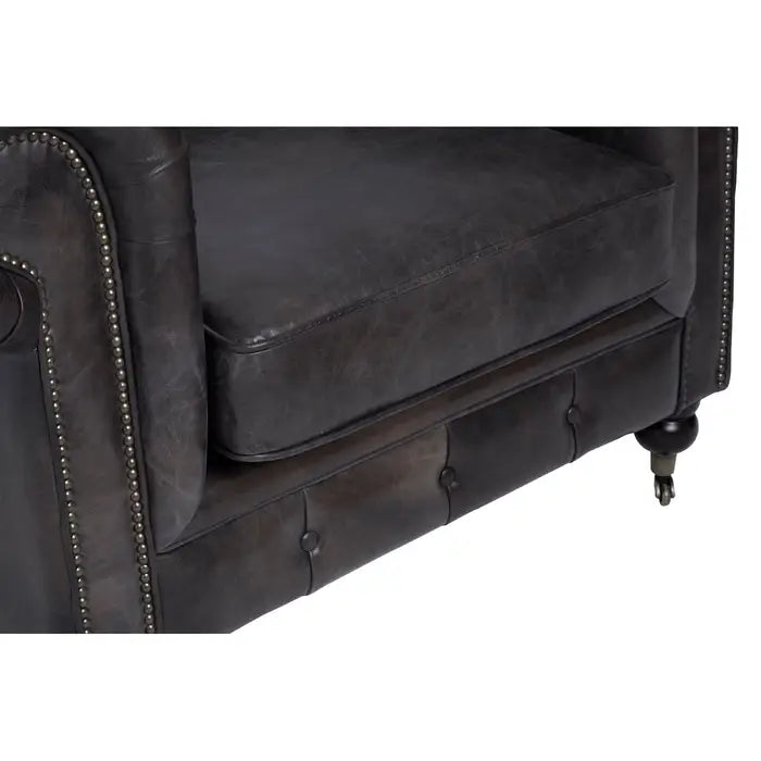 Metallic studs trace the lines of the large rolled armrests, and the traditional Chesterfield style.