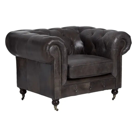 Metallic studs trace the lines of the large rolled armrests, and the traditional Chesterfield style.