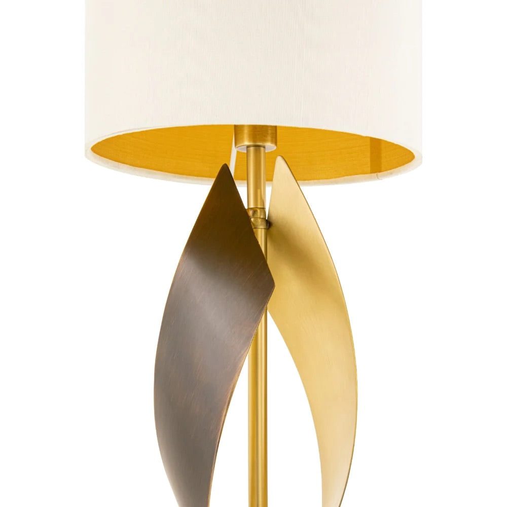 Close up of a single lamp with beautiful rich tones of ivory, coupled antique brass stem & base with plain white background.