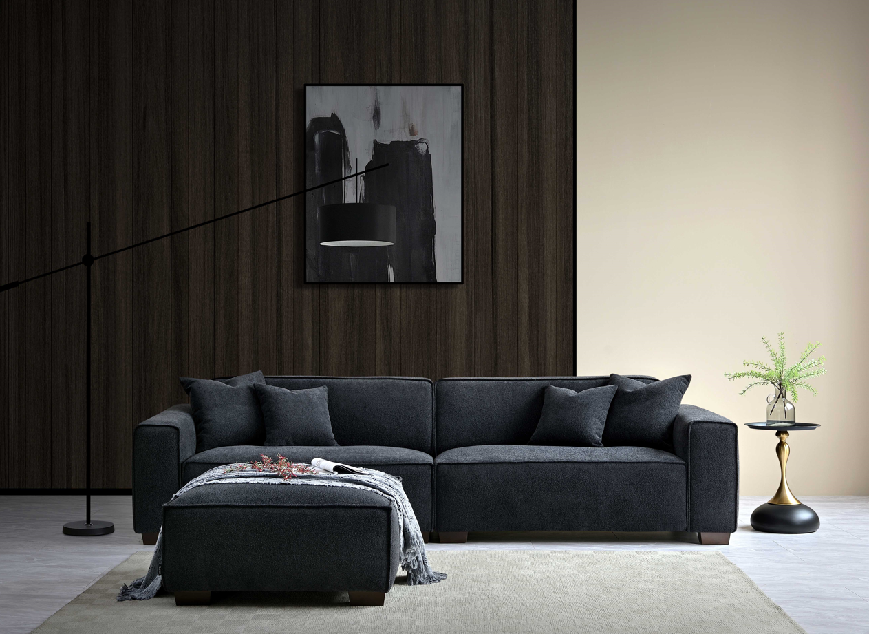 Dark wood background with over hanging lamp showing 2 seater grey soft touch sofa with football and side table. 