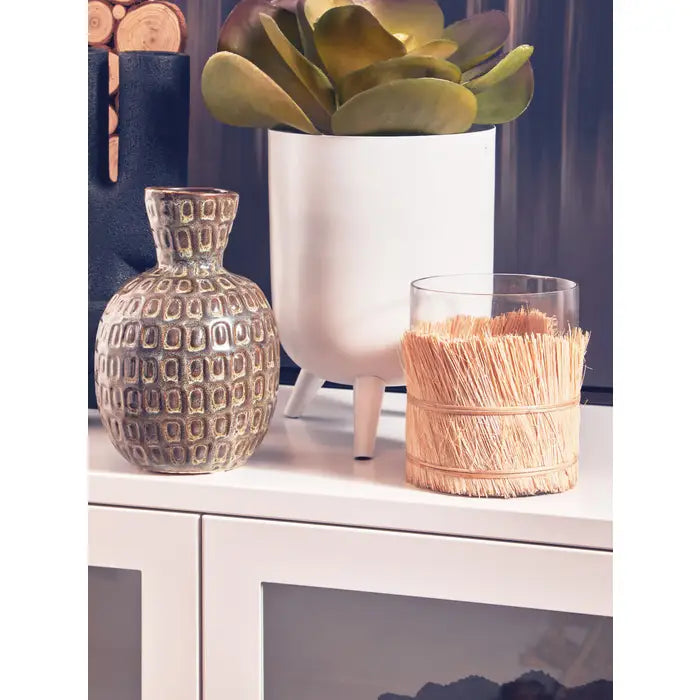 This candle holder features natural raffia that eloquently engulfs a fine small glass structure giving it a natural coastal feel.