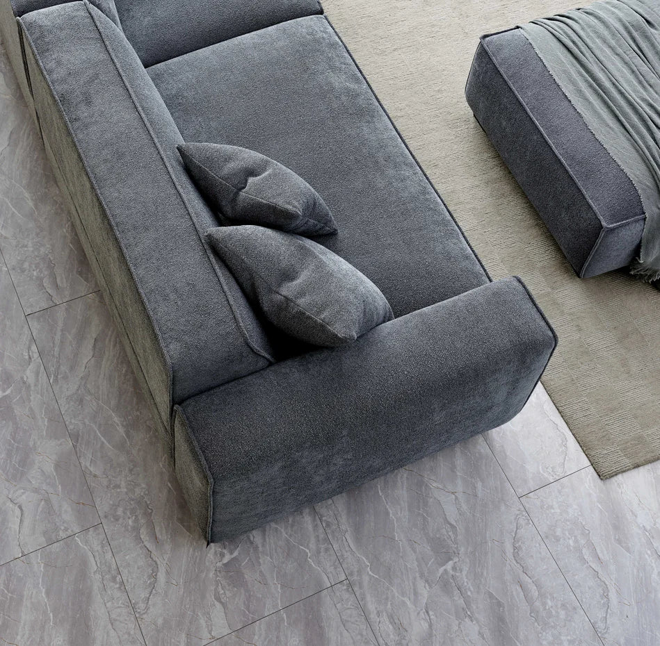 Aerial shot of grey soft touch aluxxo sofa with tiled floor and footstall with throw. 