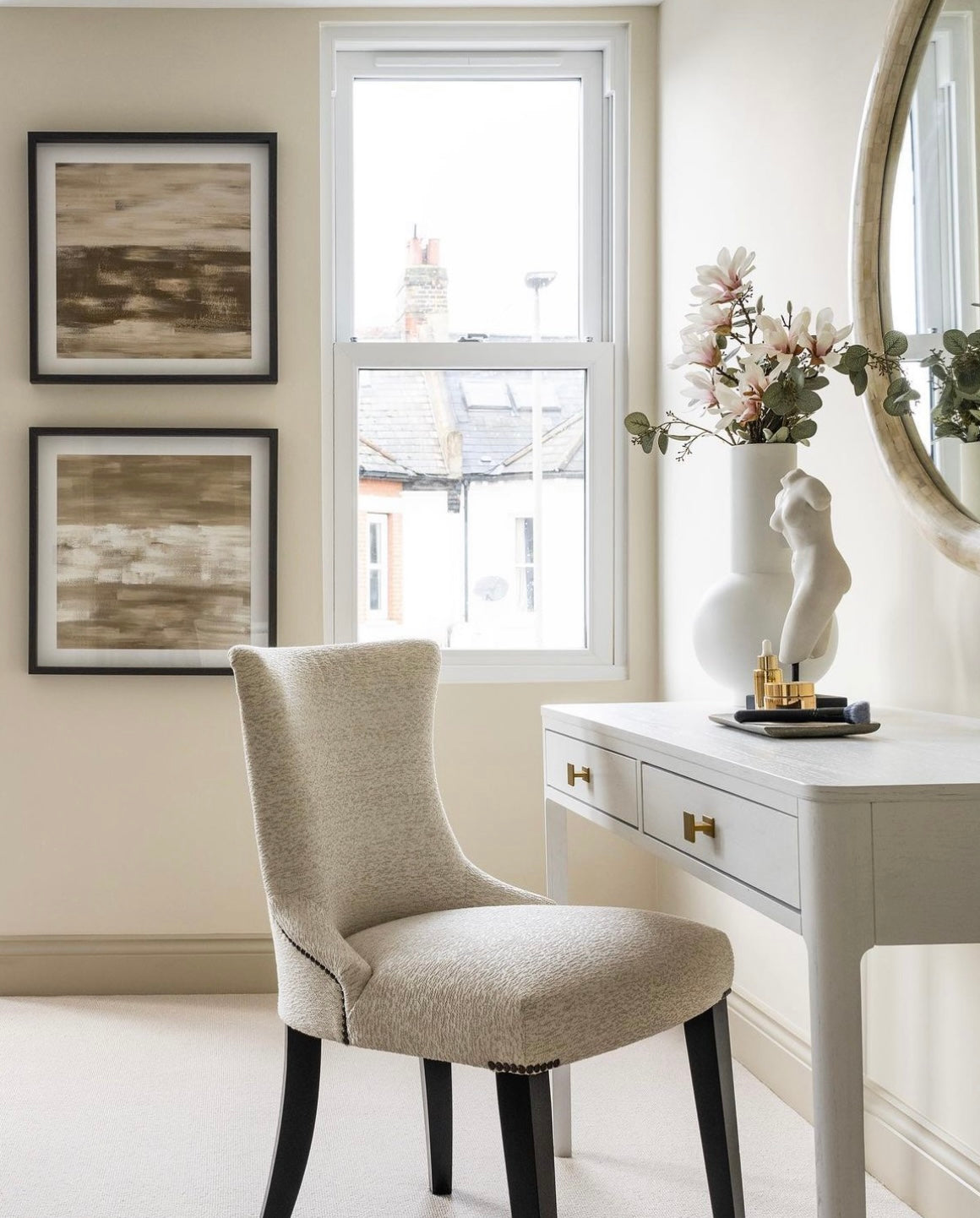 White console table with Gold handle details in a neutral setting with beauty chair, mirror and 2 wall art pieces. 