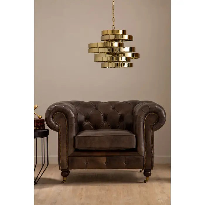 Metallic studs trace the lines of the large rolled armrests, and the traditional Chesterfield style.
