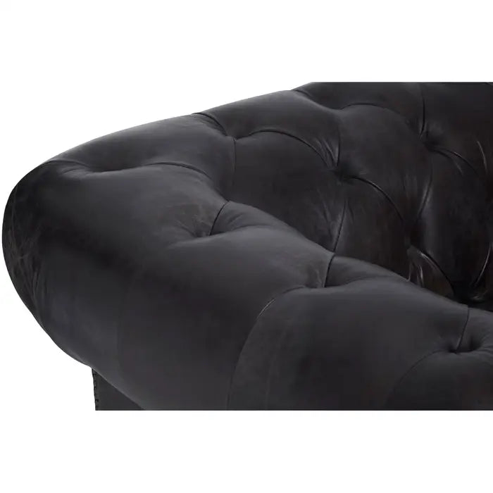 Metallic studs trace the lines of the large rolled armrests, and the traditional Chesterfield style.